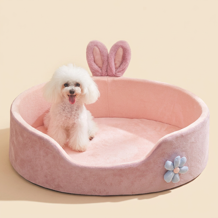 Pink bunny-ear pet bed with a small dog sitting in it