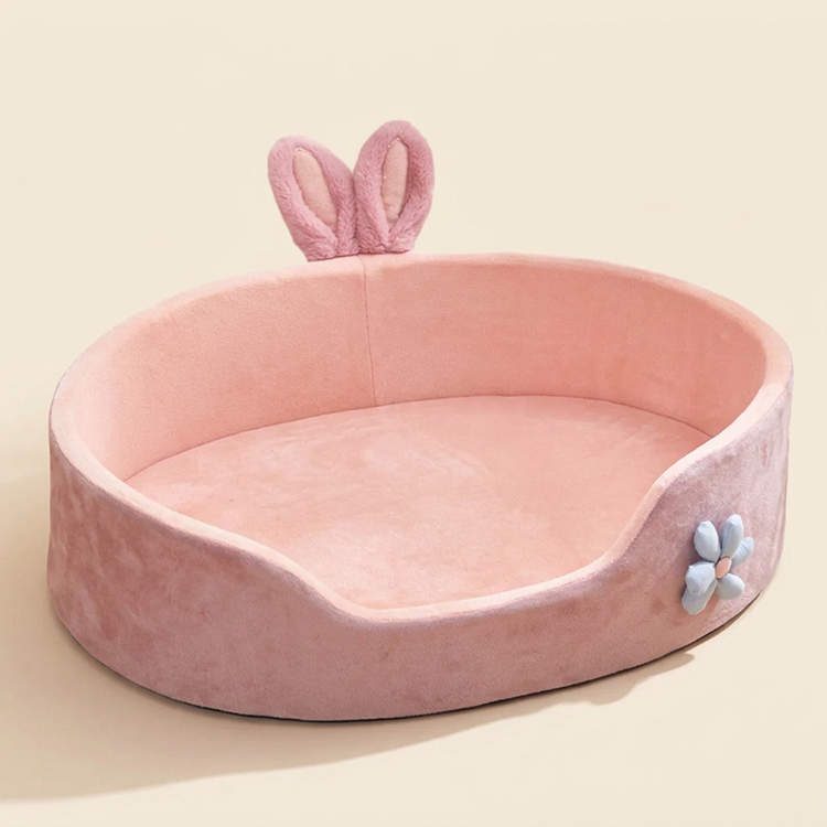 Pink bunny pet bed with raised sides and a flower detail on a cream background