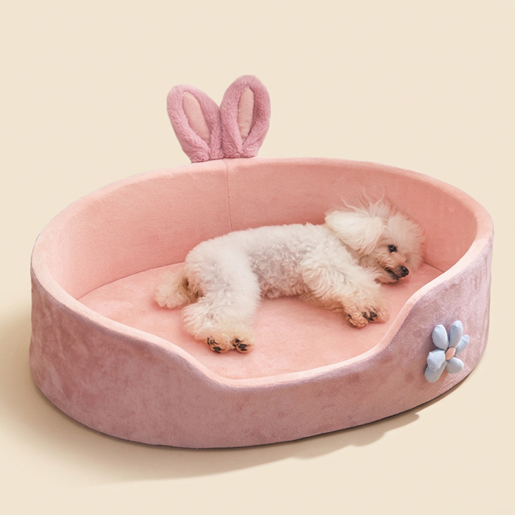Pink bunny-ear pet bed with a small dog sleeping in it
