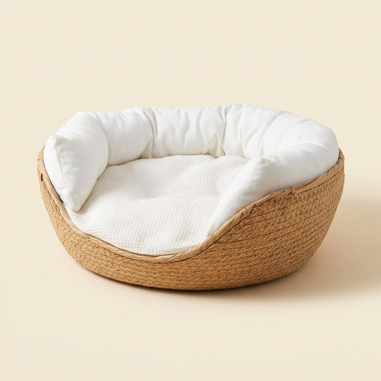 Natural woven pet bed with white cushioning on a warm cream background